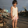 Five year old  Filipino girl Sesane Madalio poses for a portrait in the super typhoon devastated town of Guiuan on Samar Island, Philippines 20 November 2013. Sesane is living with her grandfather as her parents are working in Manila and at the time of the storm took refuge in her grandfathers house which collapsed all around them.  Now she is sheltering in a two meter by two meter shack made from the debris of the house, with her brother, cousin and grandfather.