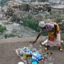A Congolese woman sets up her business selling used tins and bottles on a bridge over a polluted tributary of the Congo river running passed a slum in Kinshasa, the Democratic Republic of Congo, Tuesday 01 August 2006. The Congo river meandering through a country half the size of Europe is the lifeblood for many Congolese. Today its tributaries are choked with pollution as the country struggles to emerge from decades of poverty, disease and civil war.  The DRC held its first democratic presidential elections in more than 40 years Sunday 30 July 2006. Election results could take several weeks to be formulated.