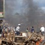 Liberians run for cover past a burning baracade in Paynesville, just outside Monrovia, 01 October 2003. Peace was shatered today as an Ecomil escorted convey of LURD(Liberians United for Reconciliation and Democracy) Rebels including LURD leader Sekou Damateh Conneh that was heading to meet Liberian President Moses Blah engaged Government forces along the way. Taunting between LURD and Government forces evolved into stone throwing and then a full gunfight. At least 2 people were killed and some injured. Angry residents blamed Peacekeepers for bringing LURD into Monrovia. <br />