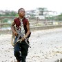 A child Liberian government gunman at the 'Old Bridge' returns from firing across at (LURD) Liberians United for Reconciliatrion and Democracy rebels  on the other side Monrovia 30 July 2003.This the Twelveth day of continued fighting for the capital despite the call for ceasefire. Battles are centred around the New, Old and Stockton bridges leading into the city.