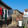 A South African woman carries water after washing clothes outside her shack  in Masiphumelele, an informal shack settlement in Cape Town, South Africa, on 16 May 2011. Housing and service delivery to poor areas are the major issues facing the ruling African National Congress (ANC) and its opposition parties as South Africans head to the polls 18 May 2011 to cast their ballots in the local government elections.  The ANC is expected to loose ground on oppostion parties in these elections seen as a barometer to the changing political landscape in Africas most successful democracy. 