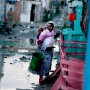  A South African woman carrying her baby and a bucket of drinking water walks along a flooded road in the impoverished informal settlement of Lotus outside Cape Town, South Africa 21 May 2007. More than 800 people were displaced from their flooded shacks as torrential rains and gale force winds wreaked havoc across the Western Cape over the weekend in the wake of a powerful storm.The cold and windy weather  is set to continue through the week according to South African meteorologists who forecast more cold fronts will sweep over the country in the next few days.  