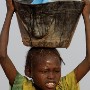 A Sudanese girl IDP (Internally displaced person) carries water from a water distribution point to her shack in Muhajiriyah IDP camp home to more than 35 000 IDP's in the SLA (Sudan Liberation Army) controlled area of South Darfur, Sudan, Thursday 21 October 2004.<br />