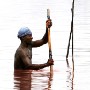 A Senegalese salt miner scrapes the bottom to gather salt from Lac Rose (Pink Lake) in Senegal, Thursday 24 February 2005. Senegal produces around 350,000 metric tons of salt every year, more than 80% of which is exported to some 15 countries in Western and Central Africa.  Most of that production comes from small producers of the Lac Rose. The Lake is pinkish in colour due to the presence of micro-organisms and the strong mineral concentration. The Lake provides a livelyhood for a large community of salt miners. The men scrape and gather salt deposited on the bottom and scoop it into boats. Then women carry the salt to the shores. Collected salt is sold with intermediaries who market it downtown.