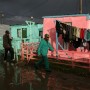 South African men walk along a flooded street in Nyanga, Cape Town 2006.