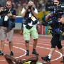 epa01459586 Usain Bolt of Jamaica is surrounded by photographers and TV cameramen as he lies on the track in jubilation after winning the men's 200m final and setting a new world record, at the Beijing Olympic games, Bird's Nest,  Beijing, China, 20 August 2008.  EPA/NIC BOTHMA