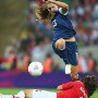 USA's Alex Morgan (R) jumps over the slide tackle of Japan's Saki Kumagai during the Women's Football gold medal match